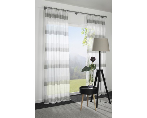 Pièce décorative avec rideaux rayés, lampadaire et table d''appoint devant la fenêtre