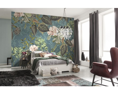 Schlafzimmer mit floraler Tapete, Bett, Teppich und Sessel