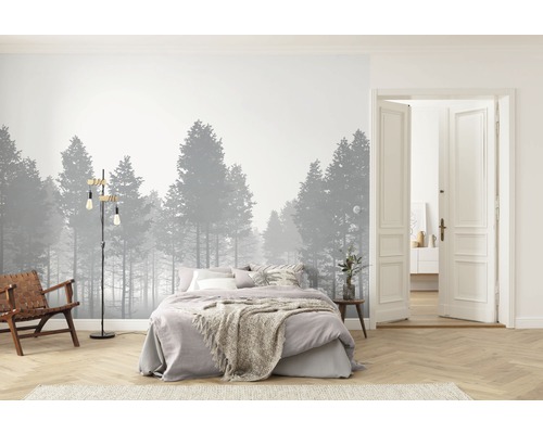 Chambre avec papier peint forêt, lit, fauteuil, lampadaire et porte ouverte