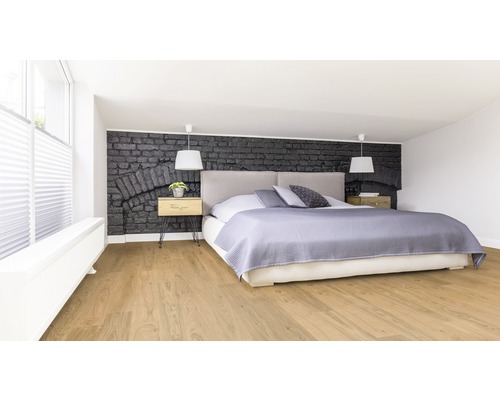 Chambre à coucher avec lit, tables de chevet et mur aspect pierre