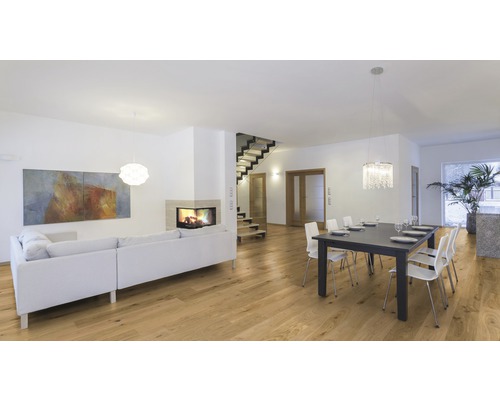 Heller Wohnraum mit Holzboden, Kamin, Sofa und Esstisch