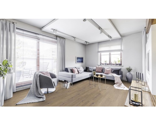 Salon lumineux avec parquet, canapé et fauteuil