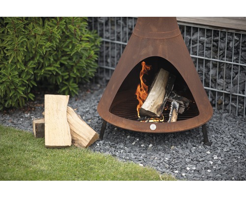 Gartenszene mit einem Chimenea-Holzofen, Holzscheiten und Kies