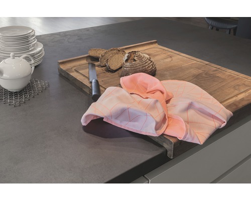 Scène d''un plan de travail de cuisine avec planche à découper, pain, couteau, torchon, théière et assiettes