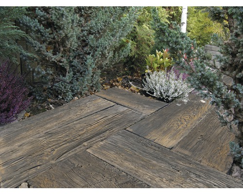 Allée de jardin en pavés de bois en motif à chevrons, entourée de plantes