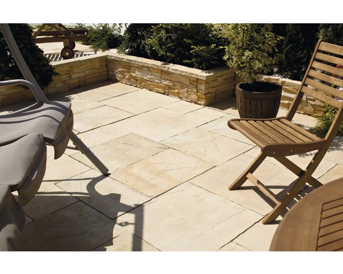 Aménagement extérieur avec dalles de terrasse, muret et mobilier de jardin