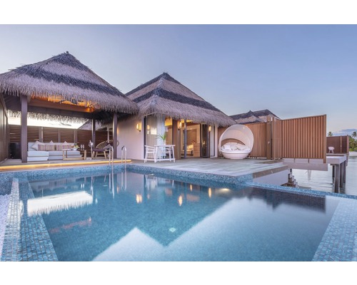 Vue d''un bungalow avec toit de chaume et piscine