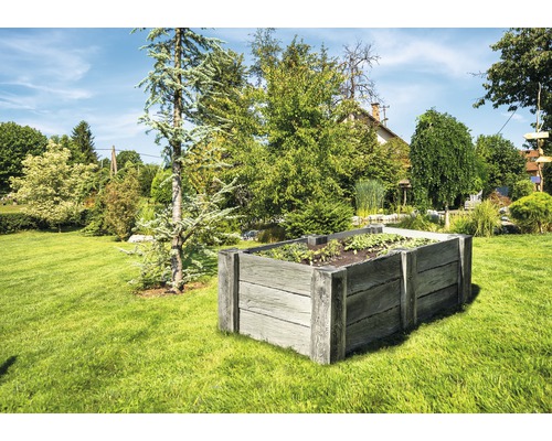 Hochbeet aus Holz in einem Garten mit Rasen und Bäumen