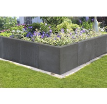 Jardinière surélevée en blocs de béton plantée de fleurs dans le jardin