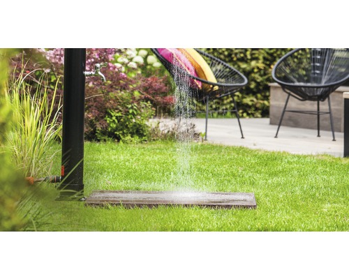 Gartenszene mit stehender Dusche, Rasen und Sitzgelegenheiten für den Aussenbereich