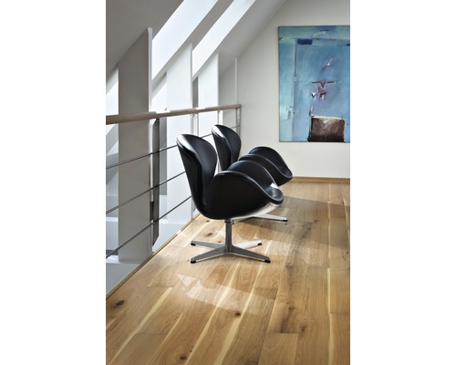 Trois fauteuils noirs sur un plancher en bois dans une pièce lumineuse