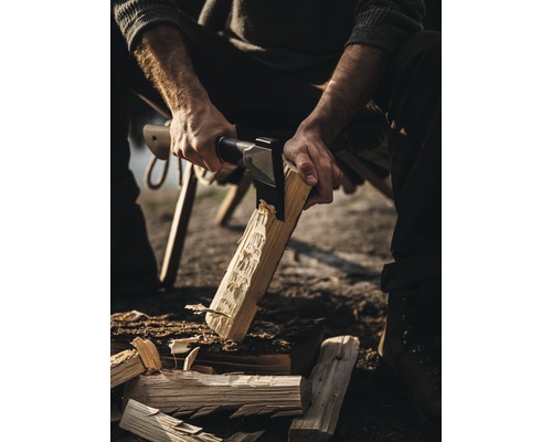 Mann spaltet Holz mit einer Axt