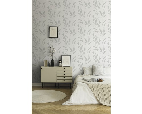 Chambre claire avec papier peint à motifs, commode et lit
