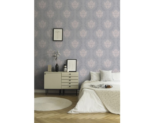 Schlafzimmer mit gemusterter Tapete, Kommode und Bett