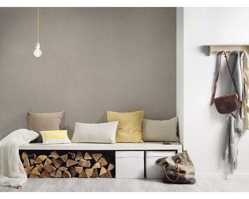 Pièce lumineuse avec banquette, coussins, bois, paniers et portemanteau