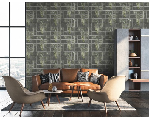Salon avec canapé en cuir marron, fauteuils et papier peint mural avec motif de feuilles