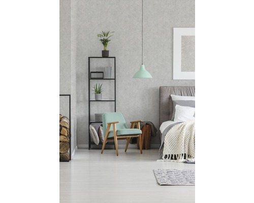 Schlafzimmer mit Bett, Sessel, Regal und Pendelleuchte