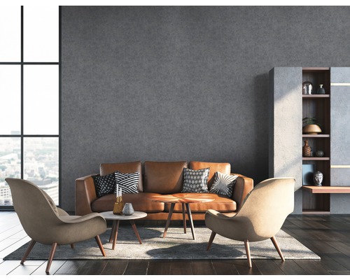 Salon avec canapé en cuir marron, deux fauteuils et mur gris