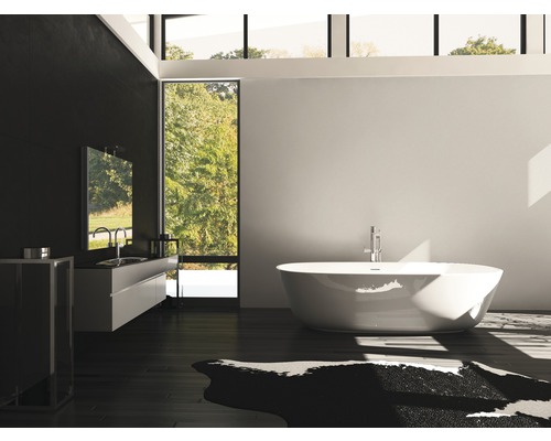 Salle de bain avec baignoire, lavabo et miroir au design moderne.