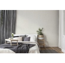 Schlafzimmer mit Bett, Vorhängen und gemusterter Tapete für eine gemütliche Atmosphäre