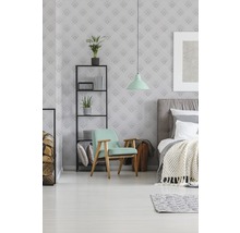 Schlafzimmer mit Bett, Sessel, Regal und dekorativer Wandtapete