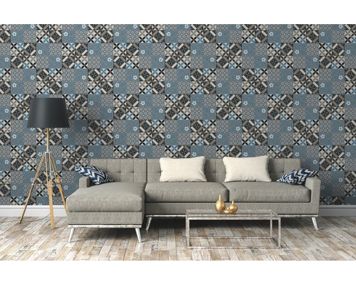 Wohnzimmer mit gemusterter Tapete in Fliesenoptik, Sofa, Stehlampe und Couchtisch