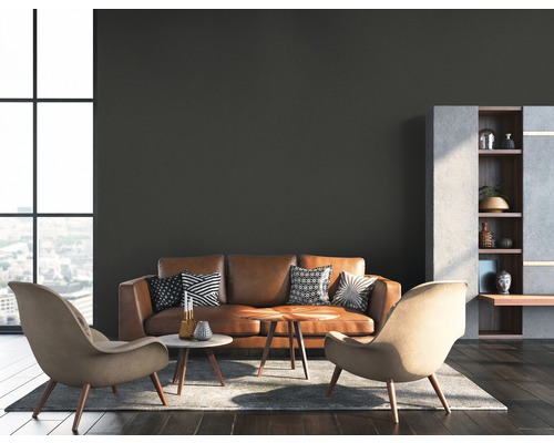 Wohnzimmer mit Ledersofa, zwei Sesseln, Couchtischen und Regal