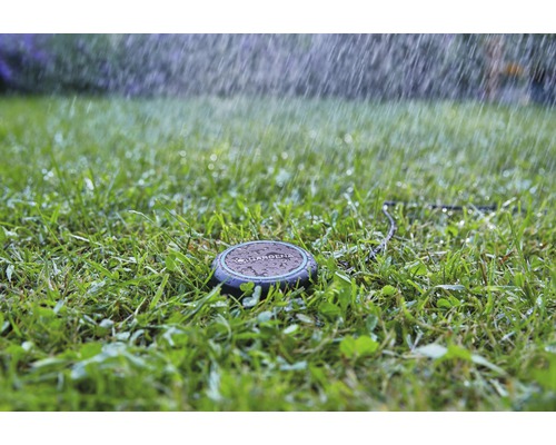 Logo Gardena sur un arroseur de gazon en cours d''utilisation sur une pelouse