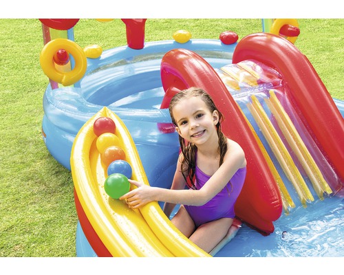Piscine gonflable avec toboggan et enfant dans le jardin.