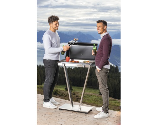 Zwei Männer grillieren auf einem Gasgrill im Freien mit Bergsicht.