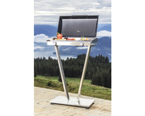 Grill mit Grillgut auf einer Terrasse mit Bergblick