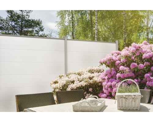 Gartenszene mit Sichtschutzzaun, Tisch und Blumen