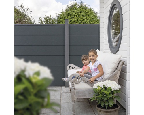 Clôture d''intimité avec des enfants sur un banc dans le jardin