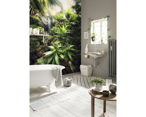 Salle de bain lumineuse avec baignoire et papier peint jungle tropical pour une atmosphère relaxante