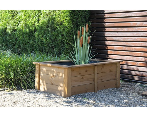 Jardinière en bois avec quenouilles dans le jardin