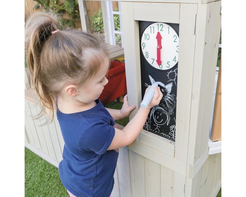 Une fille dessine à la craie sur un tableau noir d''une maison de jeu en bois.
