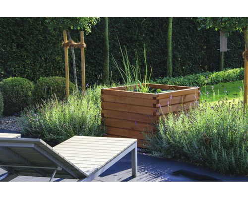 Scène de jardin avec bac à plantes en bois, chaise longue et lavande