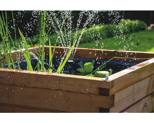 Jardinière en bois avec jeux d''eau, plantes et film pour bassin dans le jardin