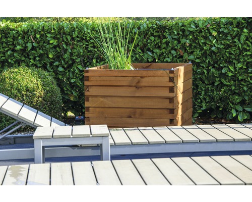 Jardinière carrée en bois dans le jardin à côté d''une chaise longue