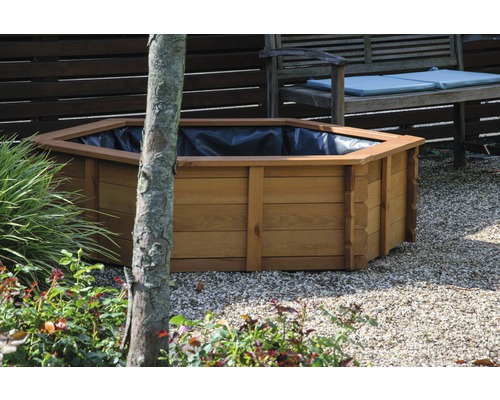 Jardinière en bois dans le jardin, recouverte d''une feuille noire