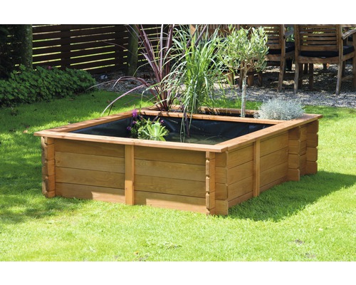 Quadratischer Pflanzkasten aus Holz mit Pflanzen auf einer Rasenfläche