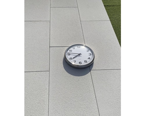 Analoge Uhr auf Pflastersteinen im Freien