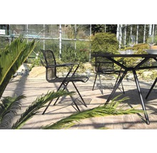 Scène de jardin avec table et chaises en métal sur une terrasse
