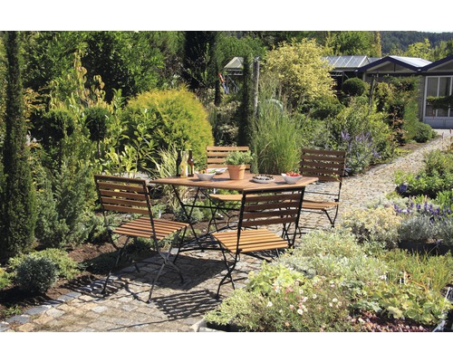 Scène de jardin avec table et chaises en bois à l''extérieur, entourée de plantes