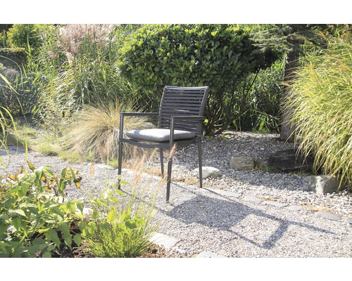 Garten mit einem modernen Gartenstuhl aus Metall und Sitzkissen.