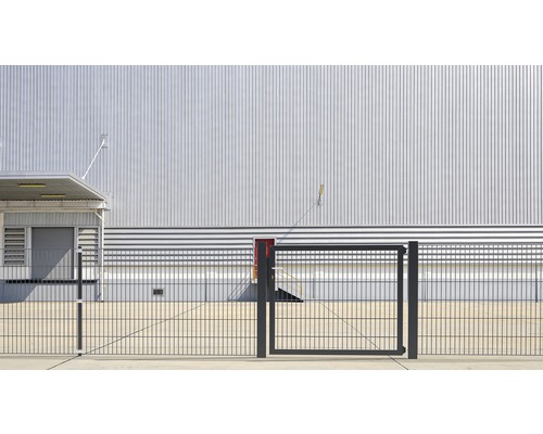 Aussenansicht eines Industriegebäudes mit Metallfassade und Zaun