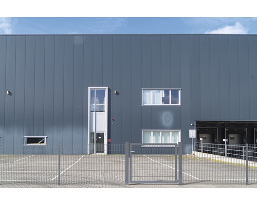 Ansicht einer Lagerhalle mit Metallfassade, Fenstern und einem Tor