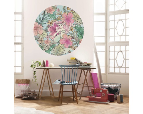 Wohnszene mit einer runden Wanddekoration mit Meerjungfrau und Blumenmuster über einem Tisch