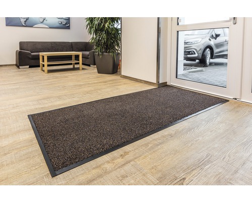 Fussmatte im Eingangsbereich eines Raumes mit heller Holzoptik.