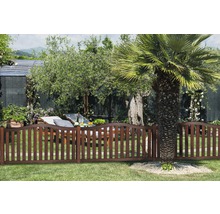 Gartenszene mit Holzzaun, Liegestuhl und Bäumen